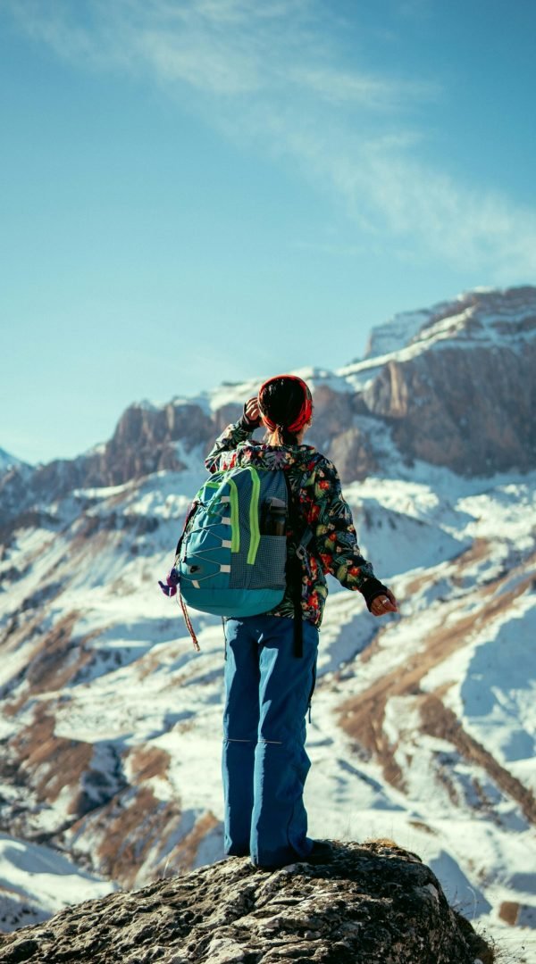 pexels-photo-29968179-29968179 Person hiking in Qusar, Azerbaijan, admiring snowy mountains under clear blue sky.